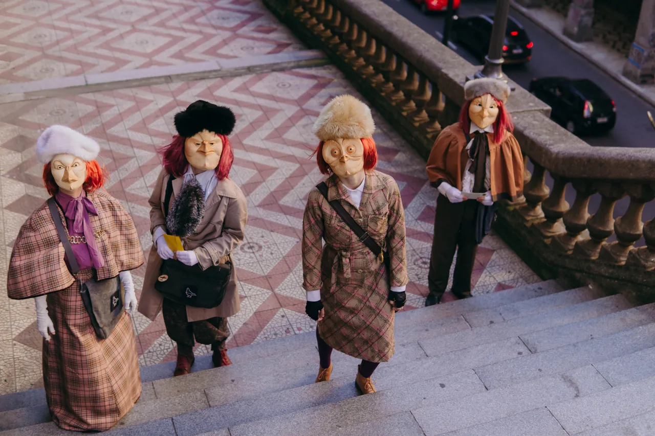 Quatro figuras mascaradas de casaco xadrez e chapéu de pele numa escadaria de calçada portuguesa